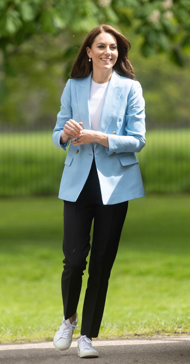Kate Middleton con blazer azul, pantalón negro y zapatillas Veja
