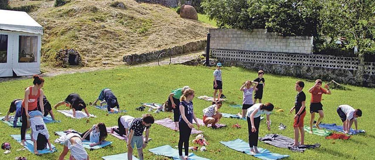 El grupo, durante la clase de yoga infantil impartida en el albergue El Furacu, frente a La Isla.
