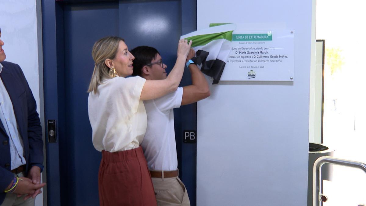 La presidenta de la Junta, María Guardiola, y el nadador Guillermo Gracia descubren la placa que da su nombre a la piscina olímpica de la Ciudad Deportiva de Cáceres