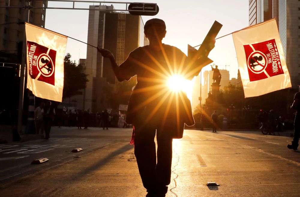 A demonstrator holds banners while marching to ...