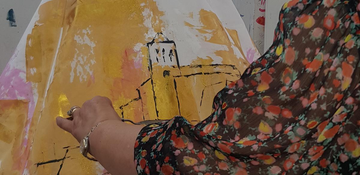Paquita Torres Cardona pintando la tela colocada en el maniquí.