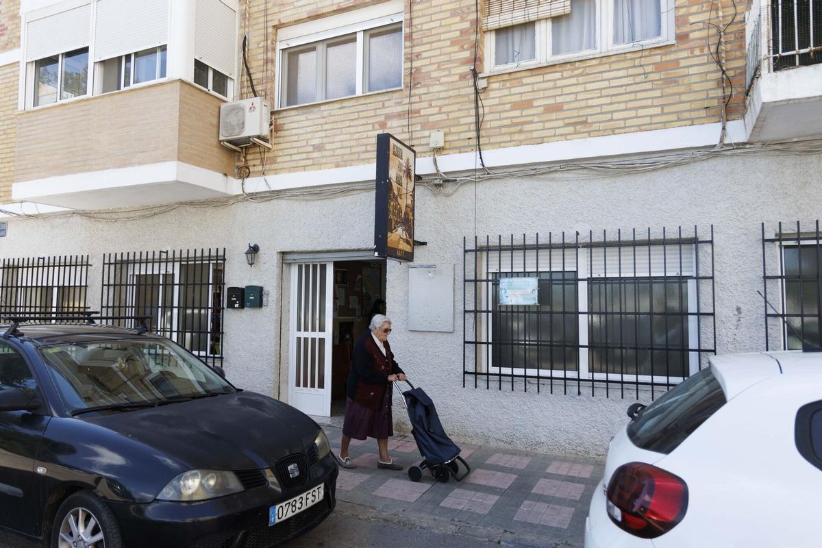 Una señora pasa por la puerta del local social de Jose María Lapuerta en Cartagena