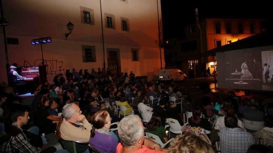 Jesús Ángel Arévalo, a la izquierda, sentado a la pianola, acompaña la proyección de &quot;El maquinista de la General&quot;, en la plaza del Paraguas.