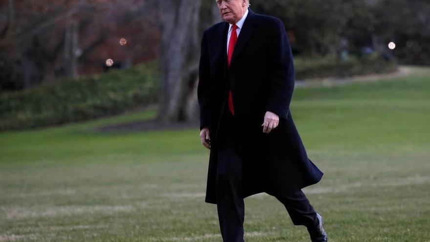 Trump camina por el prado sur de la Casa Blanca tras regresar de Misuri. En el recuadro, Michael Cohen.