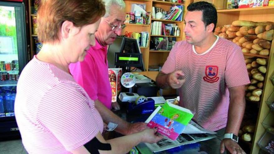 Dos lectores del periódico se detienen en su quiosco habitual a ver las nuevas recetas coleccionables que regala La Opinión-El Correo de Zamora.