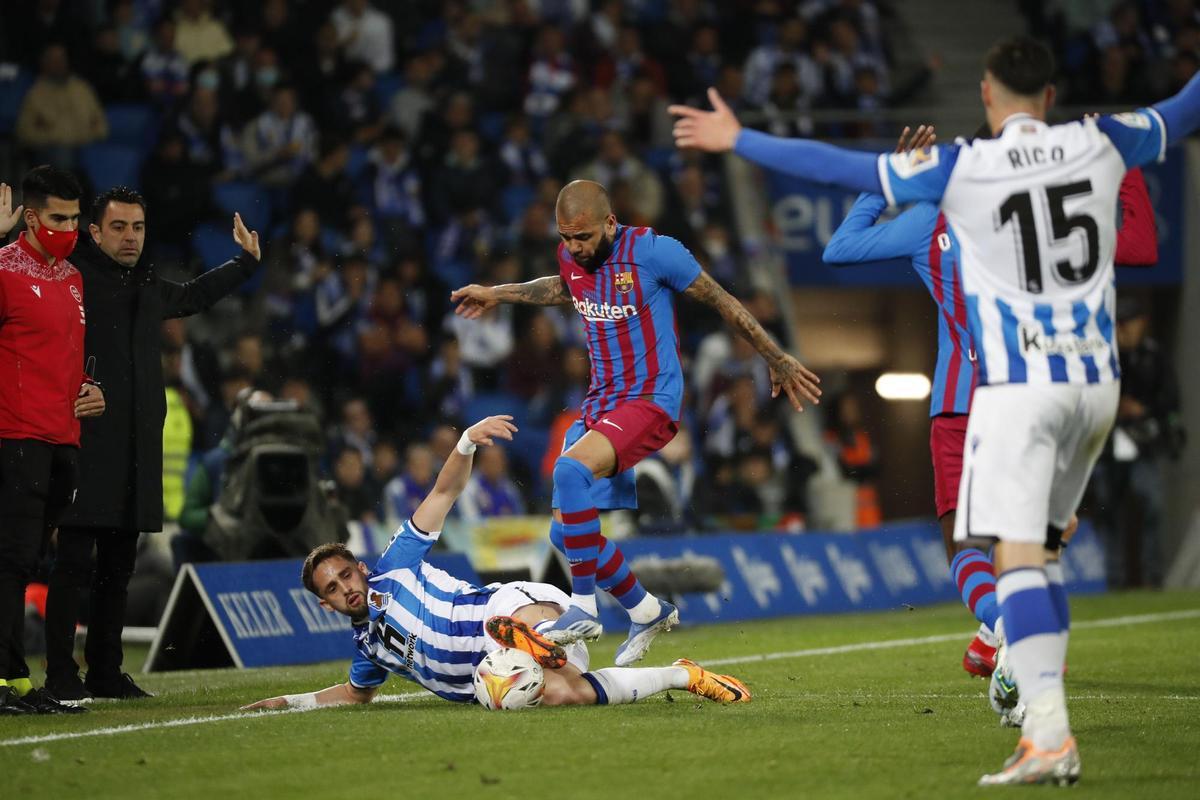 SAN SEBASTIÁN, 21/04/2022.- El centrocampista belga de la Real Sociedad, Adnan Januzaj (i), disputa el balón ante el defensa brasileño del FC Barcelona, Dani Alves, durante el encuentro correspondiente a la jornada 33 disputado hoy jueves en el Reale Arena de San Sebastián. EFE / Juan Herrero.