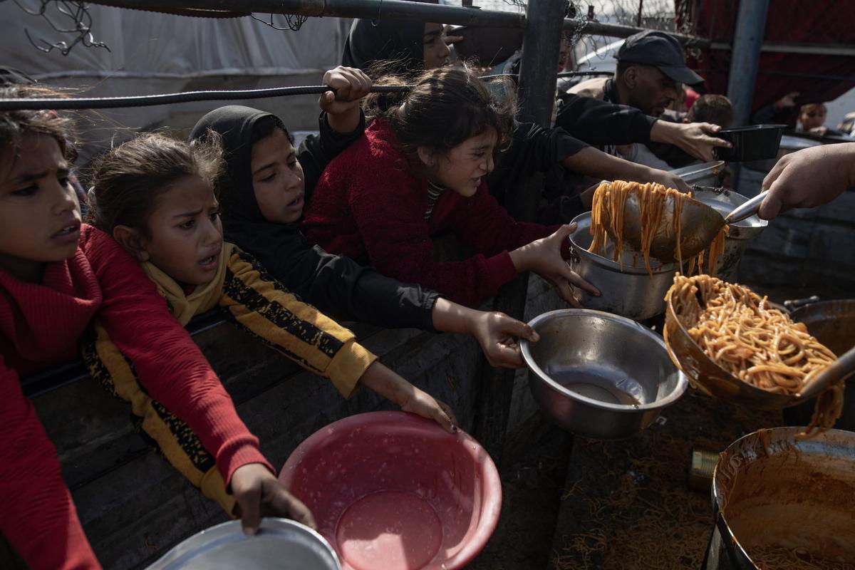 Niños palestinos, en un reparto de comida en Jan Yunis (Gaza), este sábado.