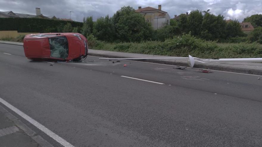 Un coche vuelca tras chocar contra una farola en la carretera de Somió