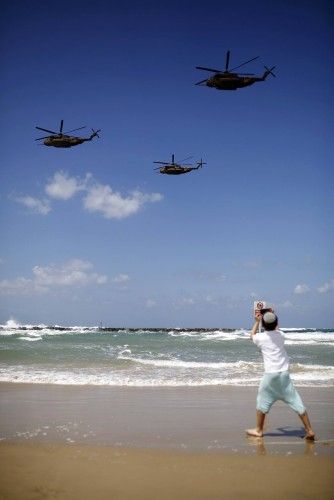 Un niño observa los helicopteros de las Fuerzas Aéreas israelíes en una playa de Tel Aviv