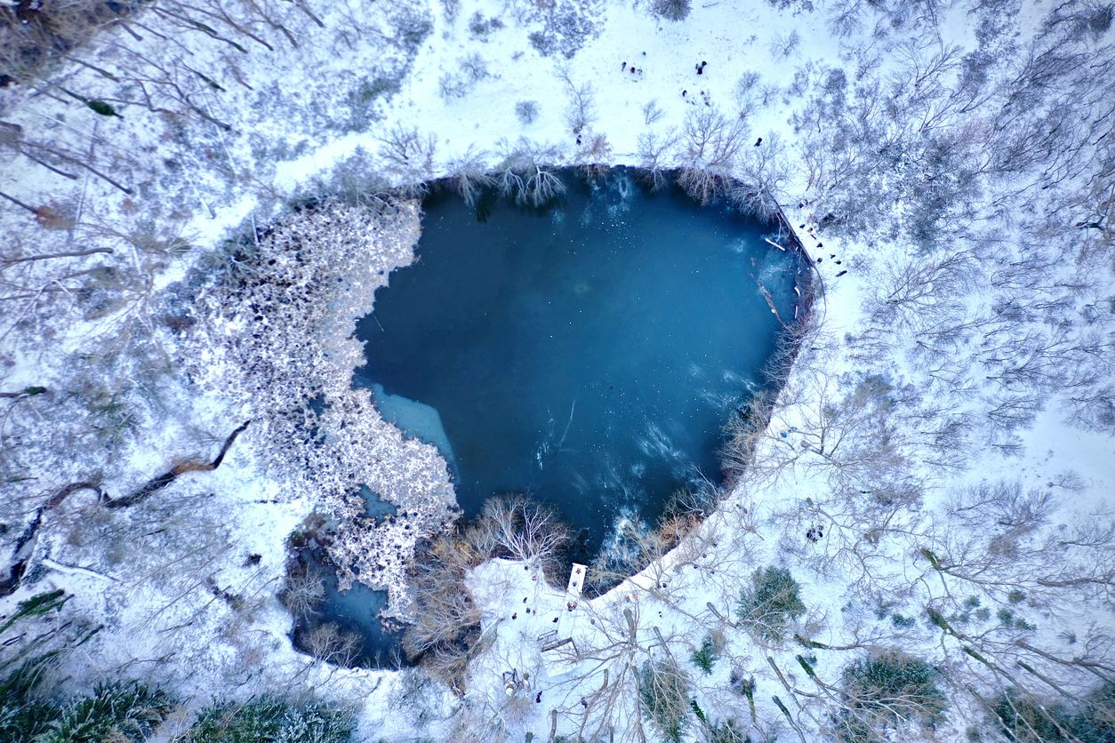 Vista aérea de la charca del bosque finlandés después de una nevada