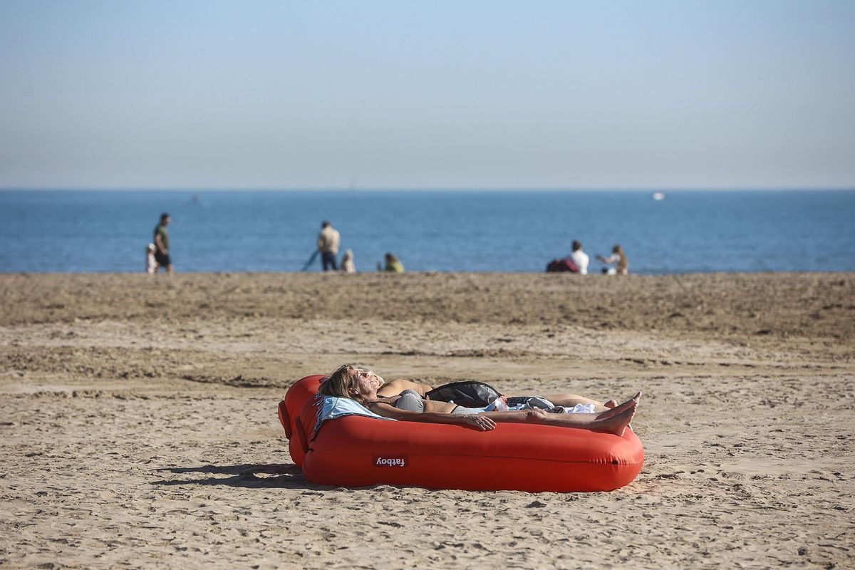 Archivo - Una mujer toma el sol tumbada en un flotador, en la playa de la Malvarrosa, a 25 de enero de 2024, en Valencia, Comunidad Valenciana (España).