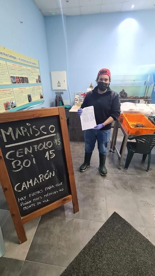 El responsable de la pescadería muestra el escrito para firmar, del que informa en el tablón.