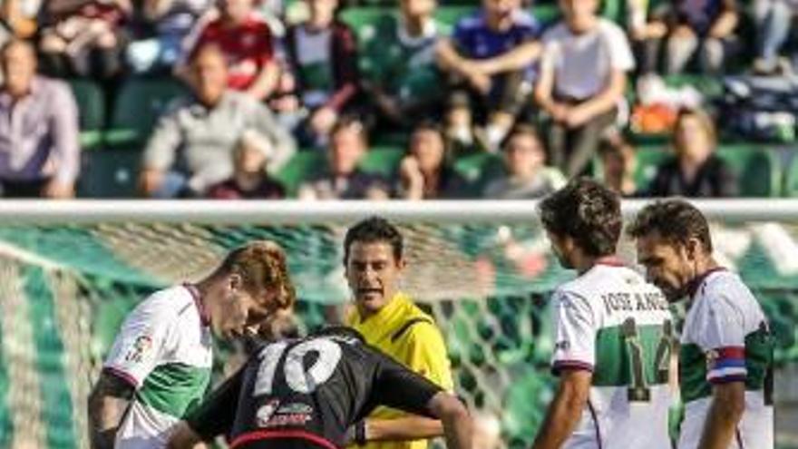 Víctor Curto está en el suelo, tras recibir un cabezazo de Mandi, que vio la roja por esta acción .