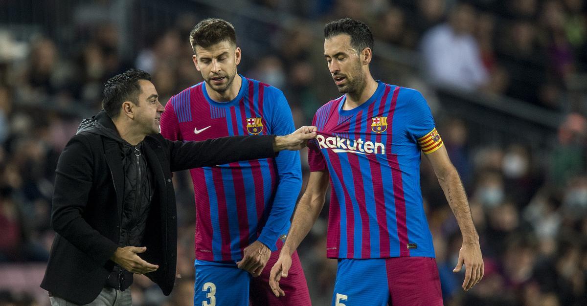 Xavi con Busquets y Piqué en la banda.