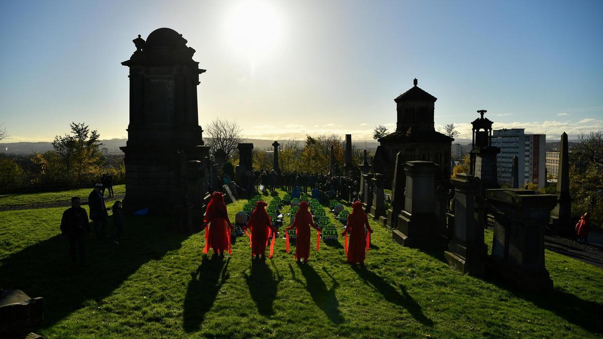 Activistas participan en un simulacro de funeral en la Necrópolis de Glasgow durante la Conferencia de las Naciones Unidas sobre el Cambio Climático (COP26) en Glasgow.