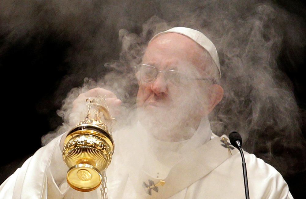 Pope Francis spreads incense at the altar as he ...