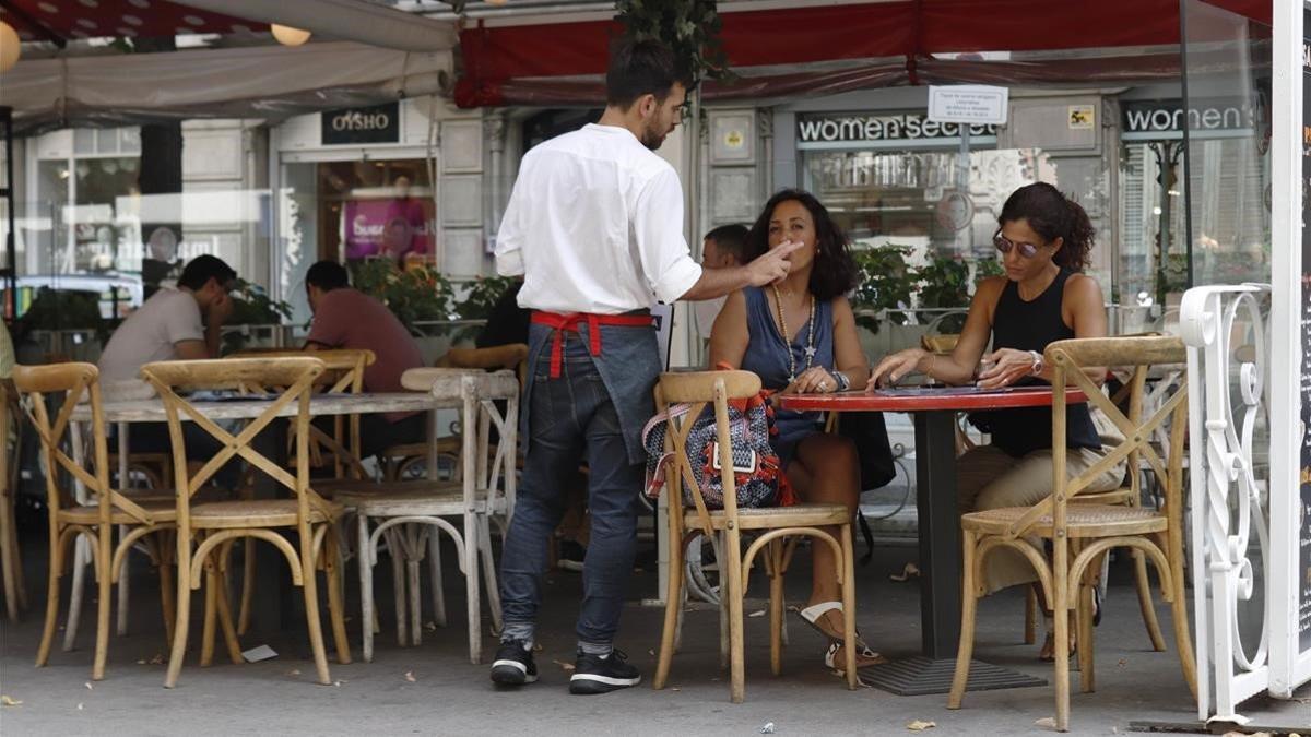 Un camarero trabajando en la Rambla de Catalunya.