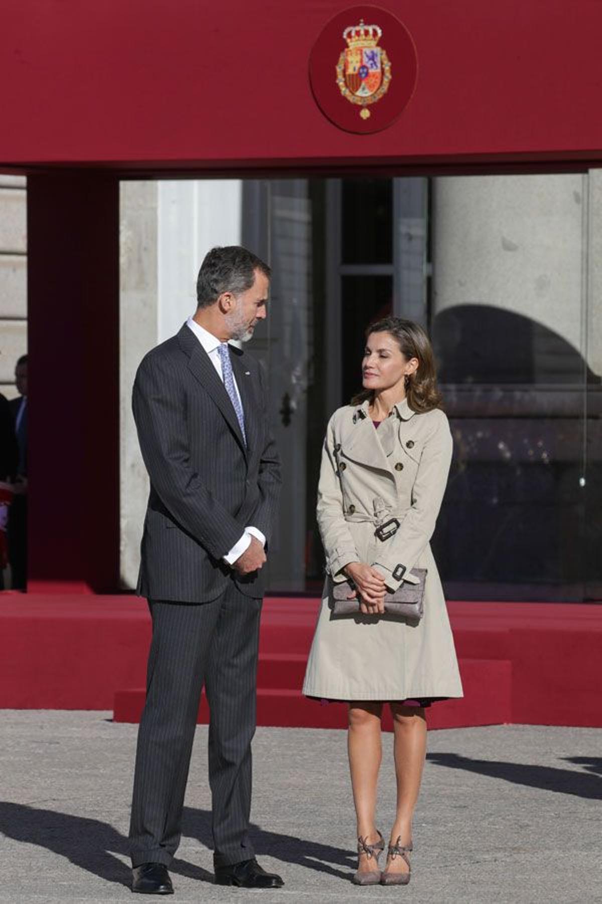 Letizia Ortiz con trench de Burberry y accesorios de Magrit junto a Felipe VI