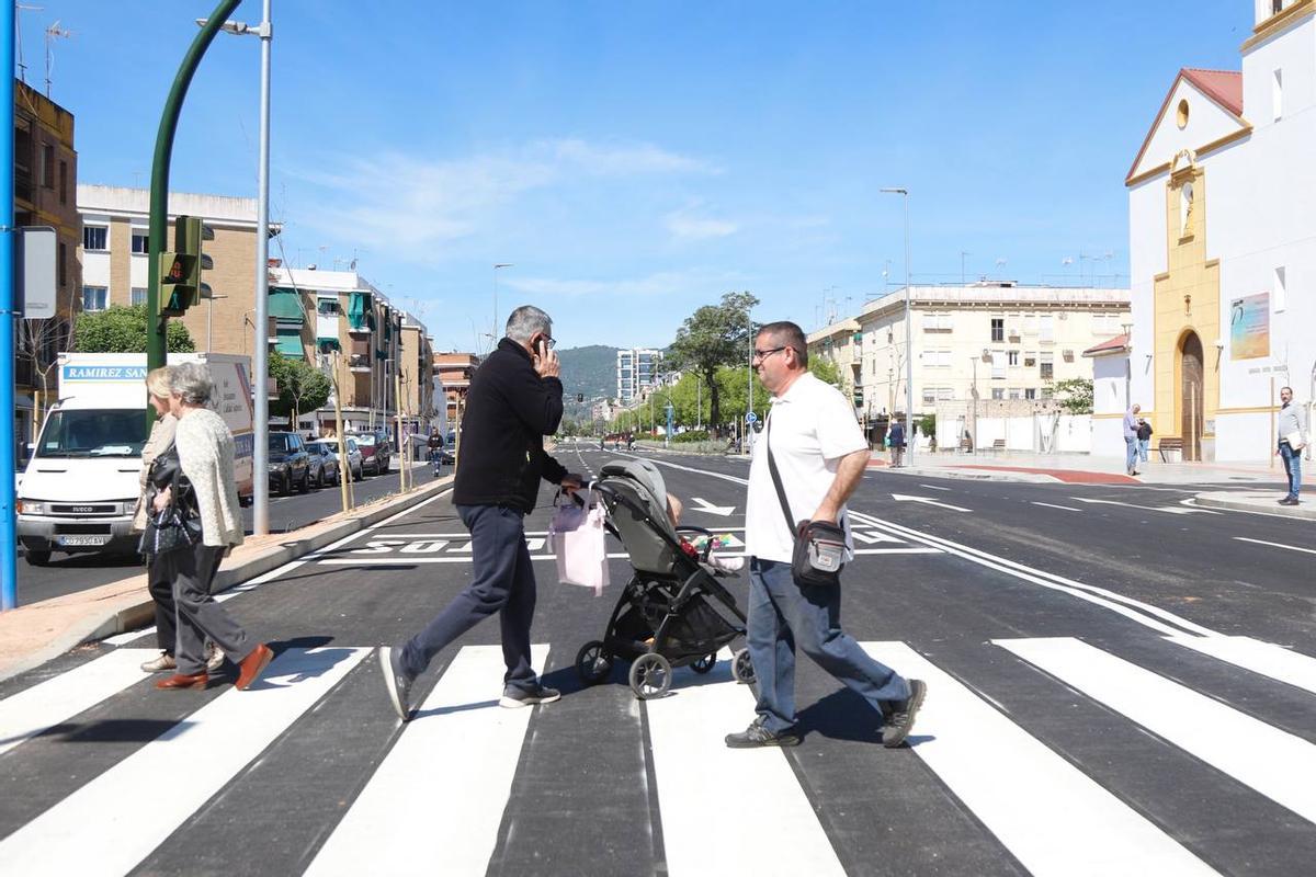 Varias personas cruzan por la avenida.