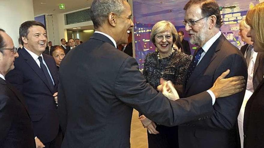 Obama saluda a Rajoy, en presencia del resto de los líderes. // Efe