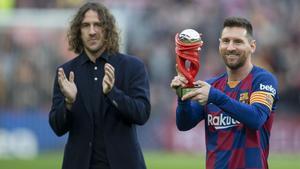 Messi recibe de manos de Puyol el trofeo que le acredita como el mejor jugador de la Liga en diciembre pasado.