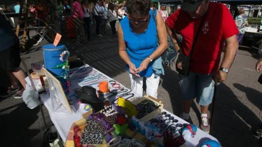 Dos instantes del «outlet» de indumentaria que organizó ayer la hoguera Sagrada Familia en la plaza Manila, previo a un almuerzo popular.