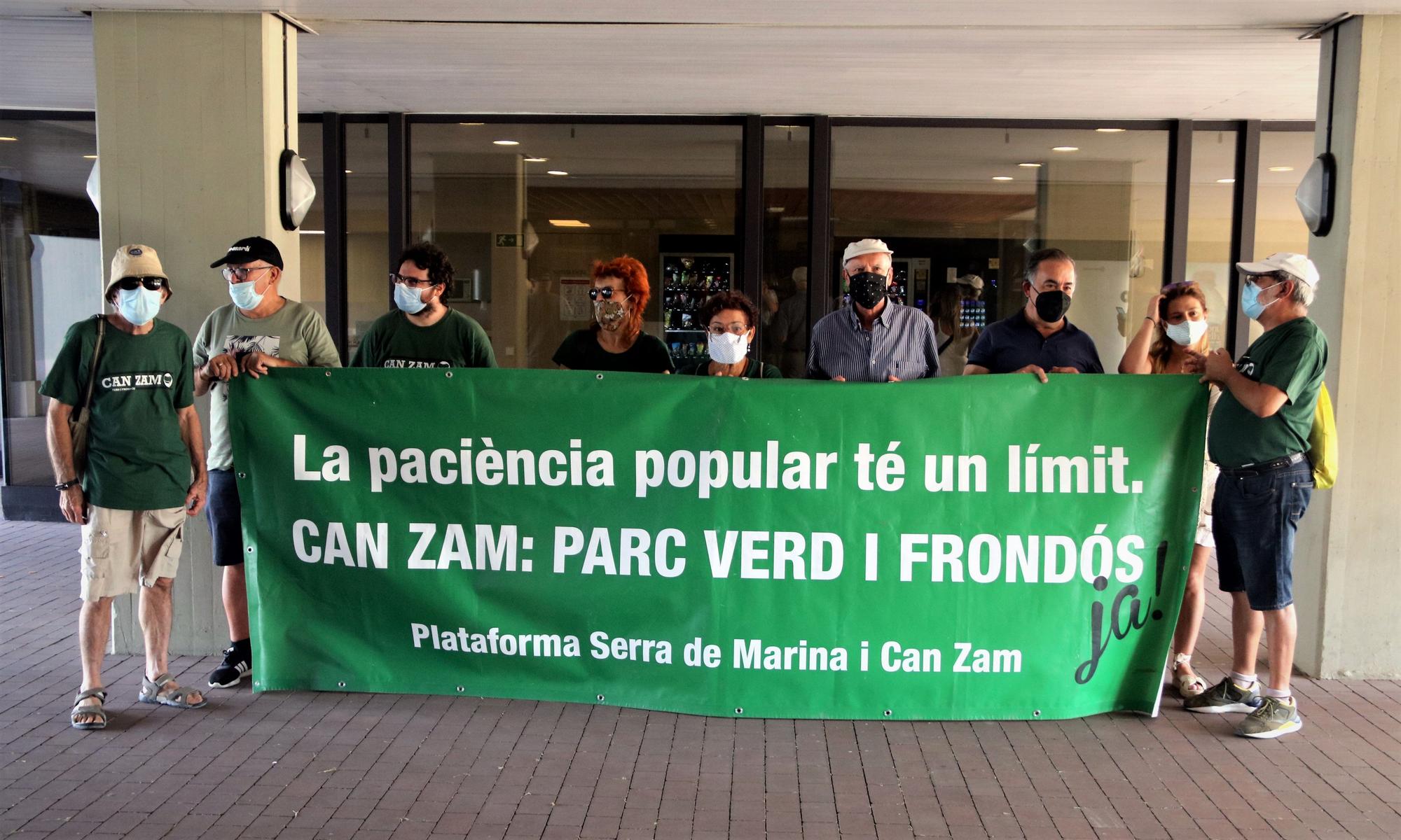 Algunos de los concentrados contra los macroconciertos en el parque de Can Zam de Santa Coloma con una pancarta ante la sede del AMB