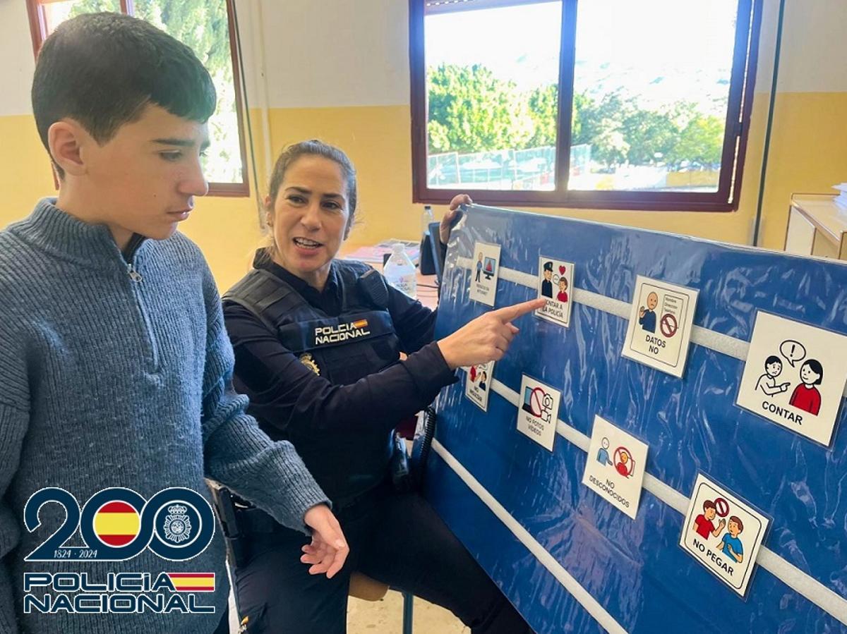 Una agente y un alumno, durante la primera charla con pictogramas.