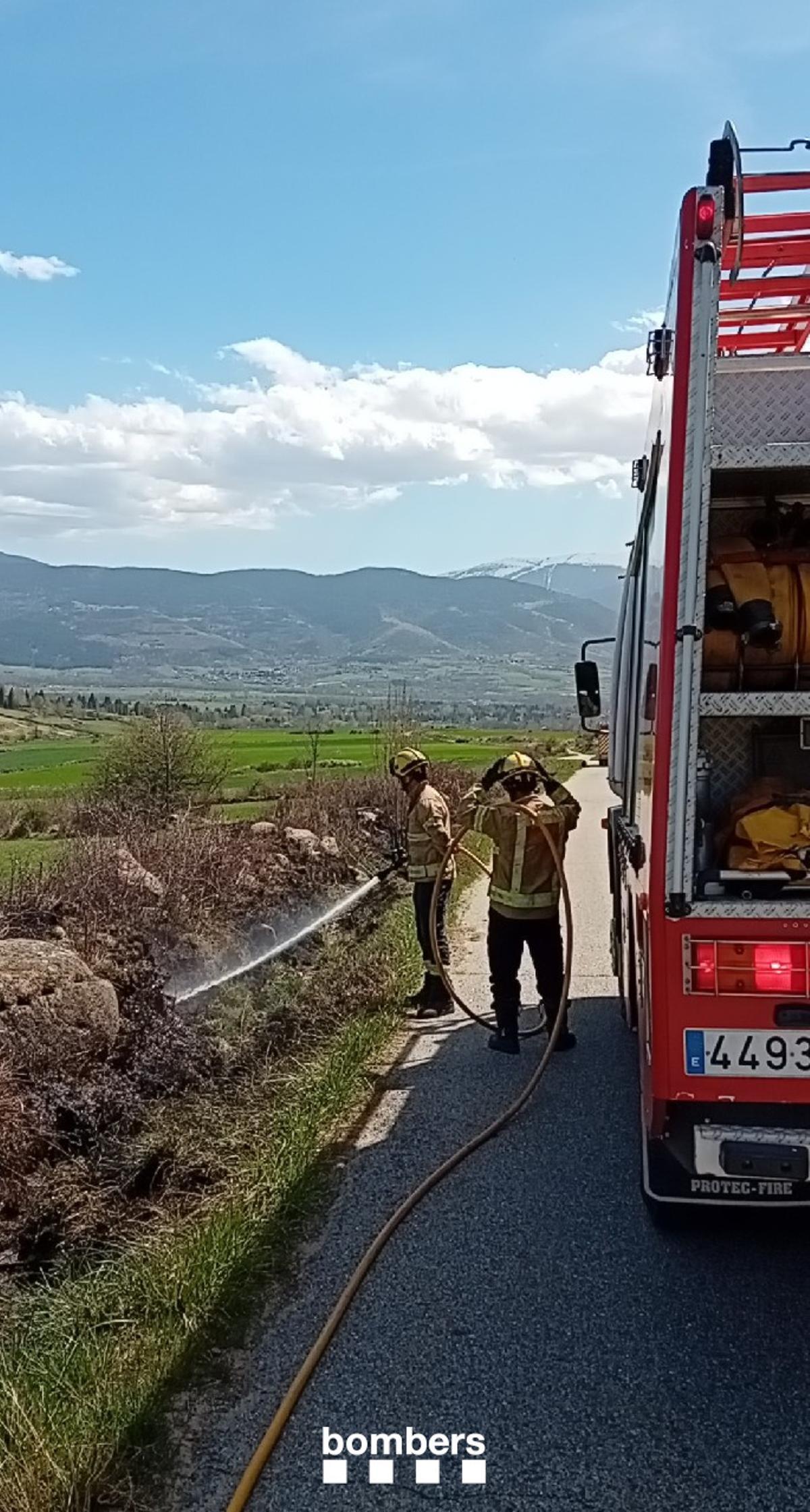 Els Bombers remullant el marge que ha cremat a Guils de Cerdanya
