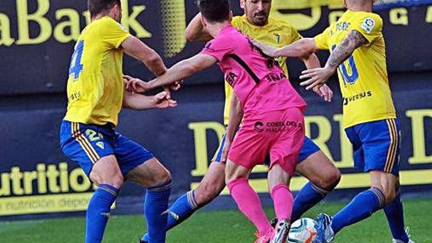 Tres futbolistas del Cádiz presionan a uno del Málaga en el partido de ayer en el Carranza.