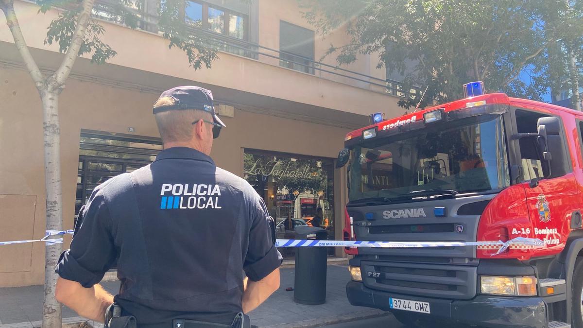 Un policía local y el camion de Bombers de Palma junto al restaurante afectado.