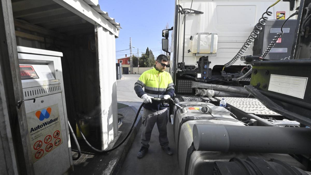 Camionero repostando gasóleo de su vehículo en una gasolinera.