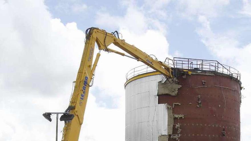 Continúa la demolición de silos en Guixar  |  Los elementos más visibles de la concesión portuaria que desde 1958 conservaba Repsol dentro del ámbito de los muelles comerciales van desapareciendo aceleradamente. En la imagen, una grúa desmantela uno de los característicos silos que como el retirado este martes lucía el logotipo de la petrolera. Se estima que en un mes la parcela de 4.000 m2 quede despejada.