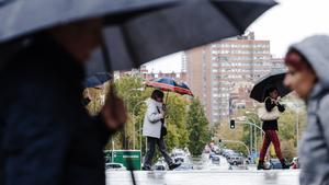 Varias personas se protegen de la lluvia con paraguas, a 2 de noviembre de 2023, en Madrid (España). La Agencia Estatal de Meteorología (AEMET) ha activado la alerta roja en Madrid por fuertes vientos provocados por la borrasca Ciarán. En la mañana de hoy, el 112 de la Comunidad de Madrid ha gestionado más de 350 expedientes por lluvia en toda la región, y los Bomberos de la Comunidad de Madrid han realizado más de 100 intervenciones. El Ayuntamiento de Madrid ha cerrado El Retiro y otros ocho parques de la ciudad ante el peligro que supone el riesgo de caída de ramas e incluso árboles. El viento de la borrasca Ciarán ha derrumbado árboles, algunos cayendo sobre coches, ha causado retrasos en la red de Cercanías por el derrumbe de un árbol sobre una catenaria y ha provocado la cancelación de 18 vuelos en los aeropuertos de Madrid, Bilbao, Asturias, Vigo y A Coruña. 02 NOVIEMBRE 2023;BORRASCA;TEMPORAL;LLUVIAS;VIENTO;ROJA;ALERTA;112;EMERGENCIAS;AEMET;BOMBEROS Carlos Luján / Europa. Carlos Luján