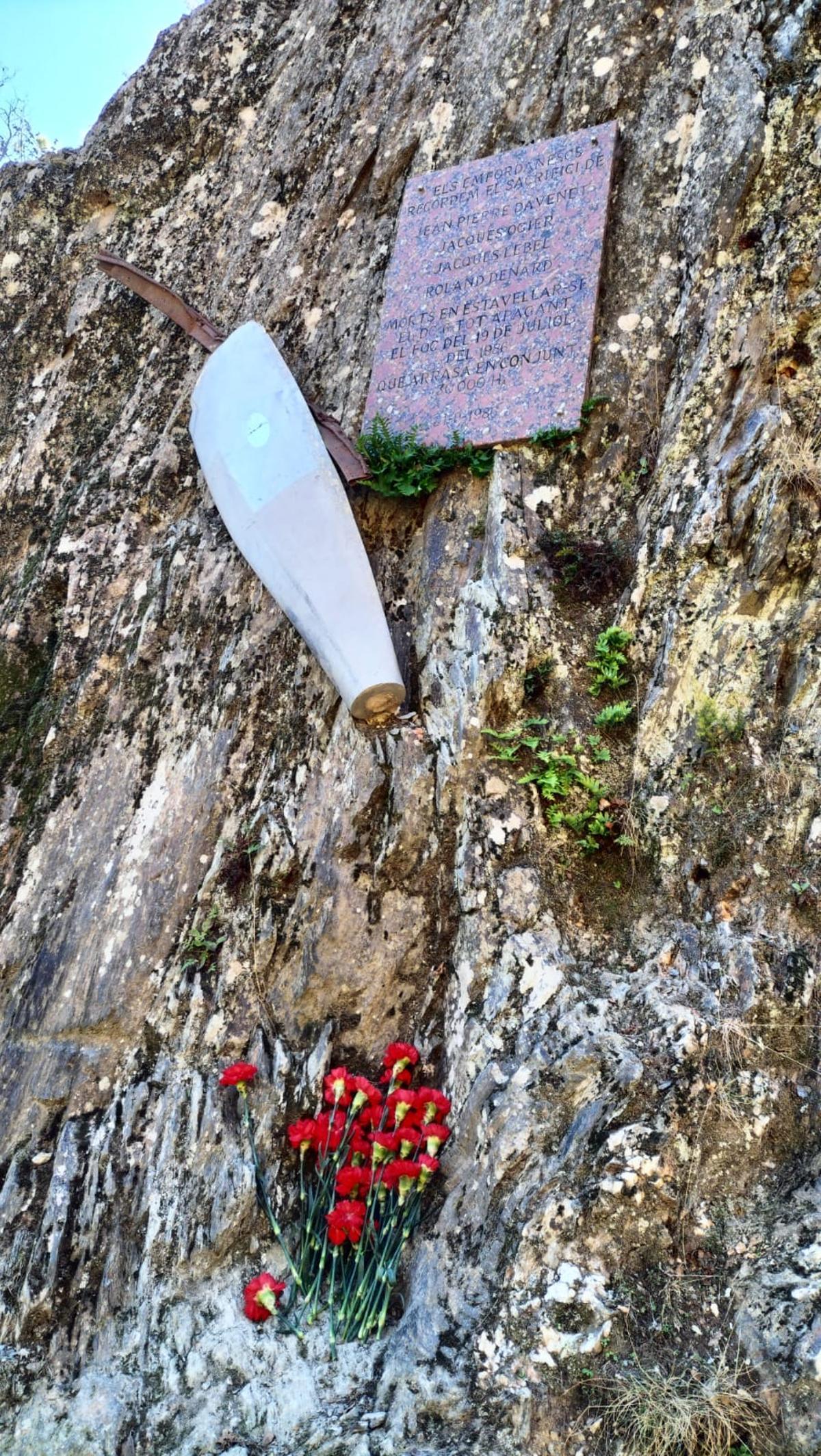 Flors dipositades a tocar la placa i una de les pales de l'hèlix de l'avió