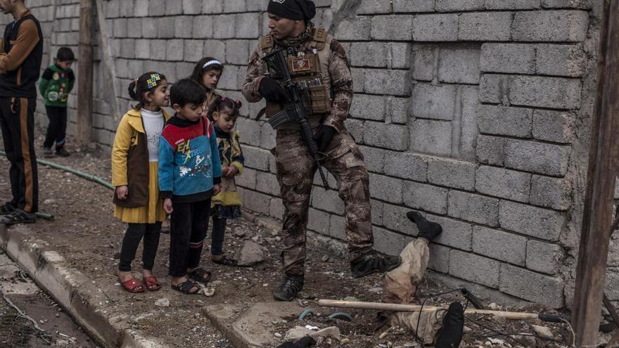 &quot;Unos niños iraquíes observan el cuerpo de un militante islámico&quot;