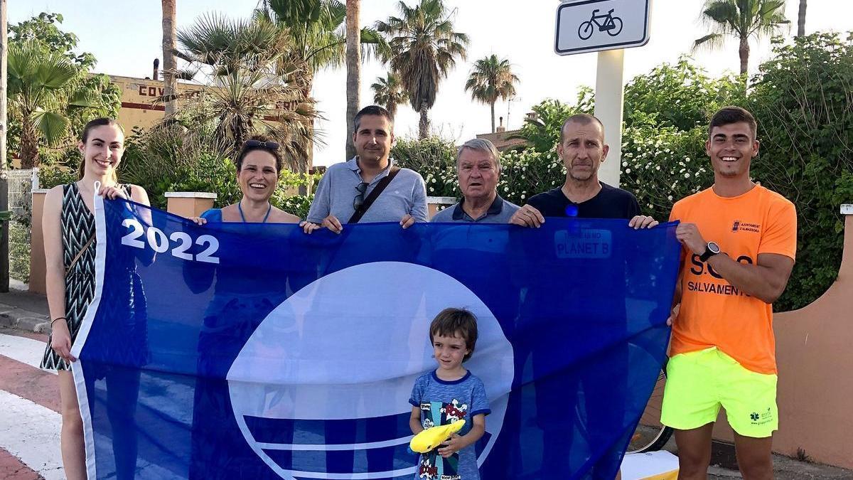 Representantes de las asociaciones Playa de Almassora y Pla de la Torre acompañaron a la empresa de socorrismo en la izada de la bandera azul en la playa de Benafelí.