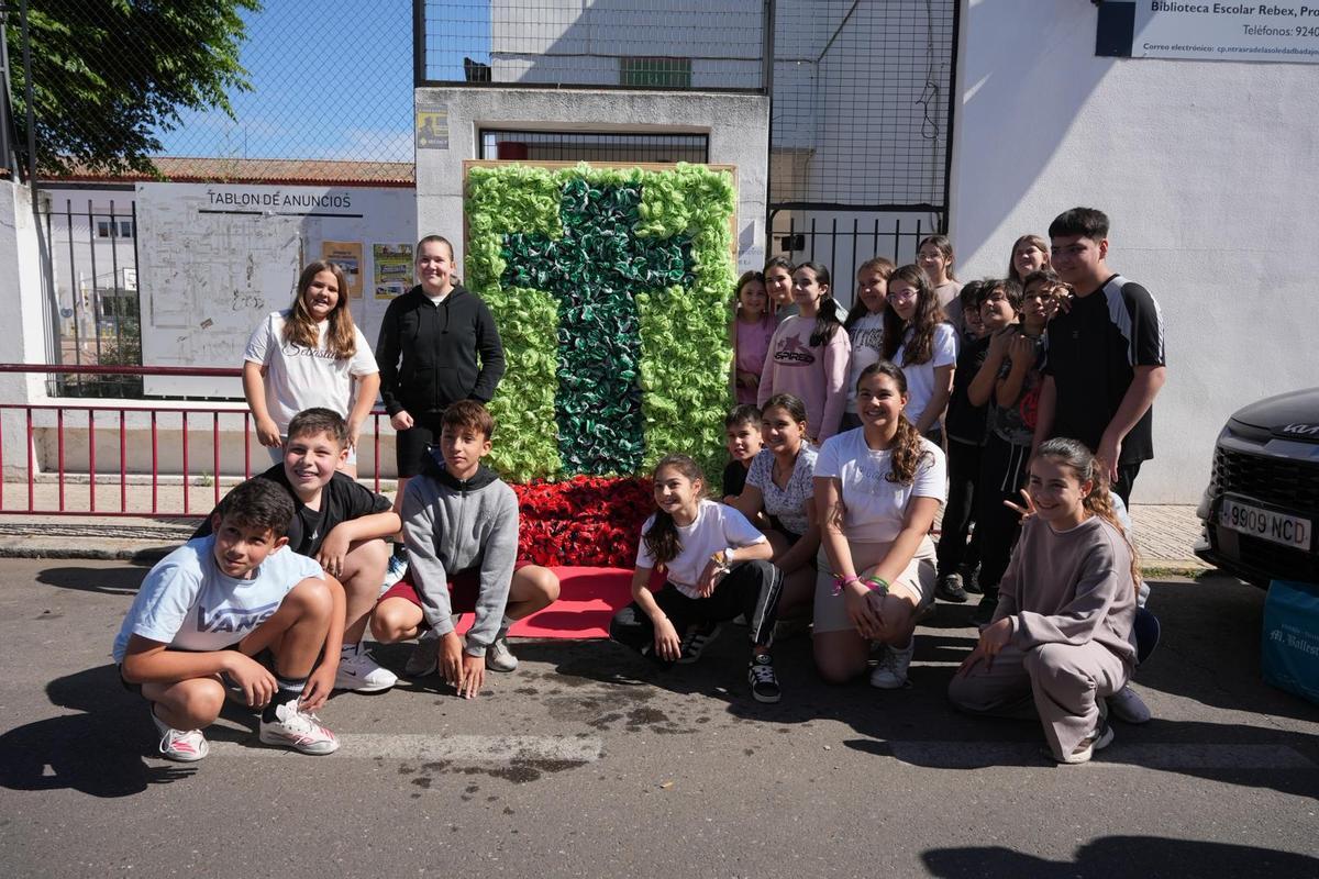 Alumnos del colegio Nuestra Señora de Bótoa de Badajoz junto a la Cruz de Mayo que han elaborado.