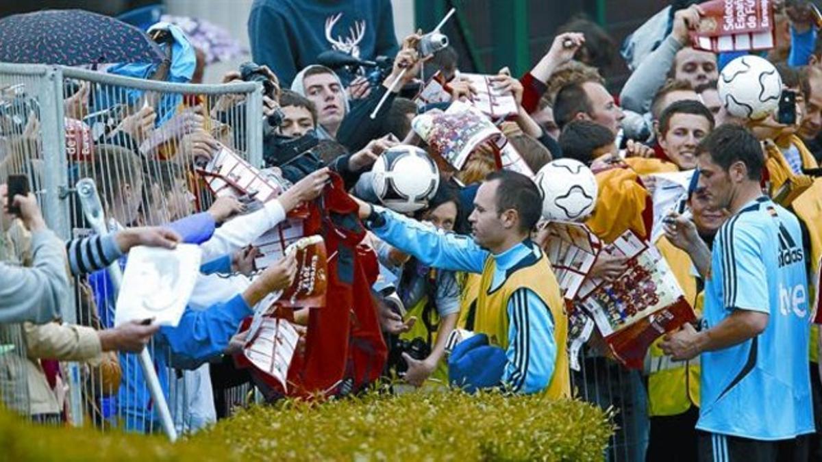 Iniesta y Casillas firman autógrafos a aficionados tras el entrenamiento de la selección, ayer.