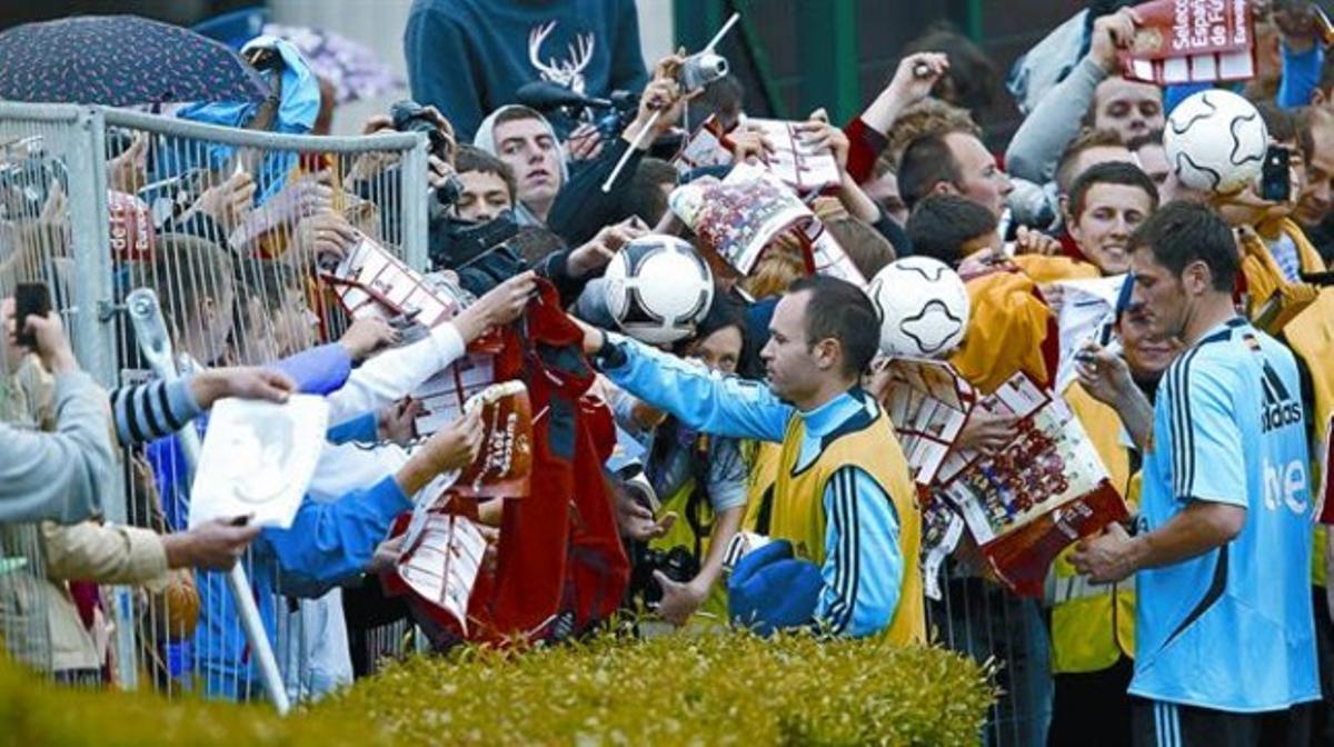 Iniesta i Casillas firmen autògrafs a aficionats després de l’entrenament de la selecció, ahir.