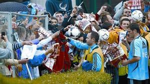 Iniesta y Casillas firman autógrafos a aficionados tras el entrenamiento de la selección, ayer.