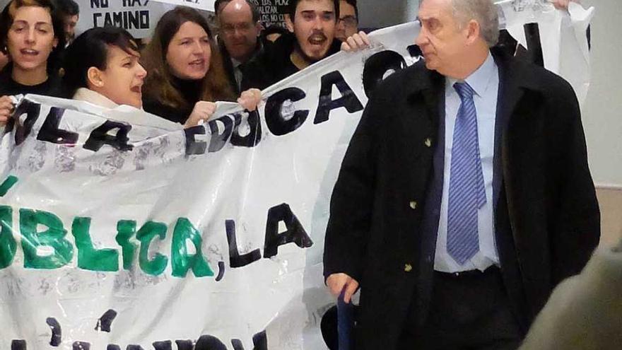 El rector, a la derecha, junto a varios alumnos que protestaban por el aplazamiento del máster.