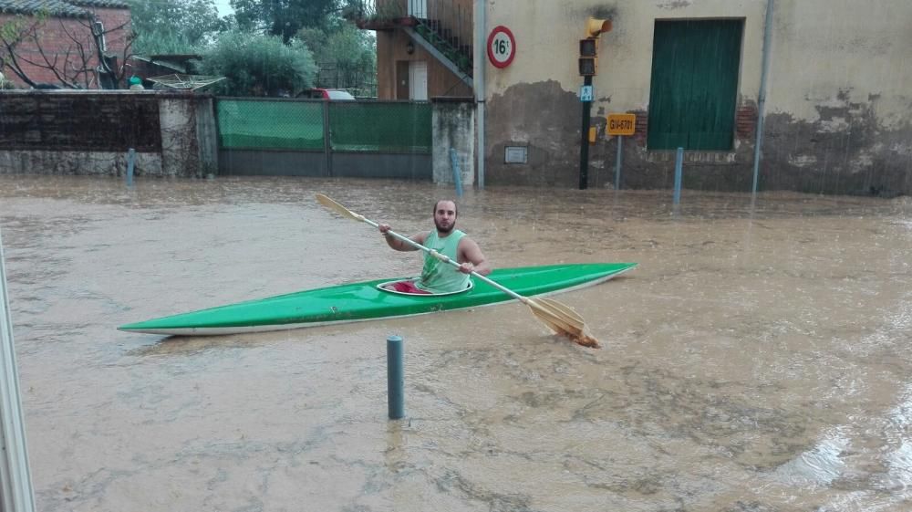 Un home amb un caiac a Bordils, navegant a la carretera que porta a Sant Martí Vell