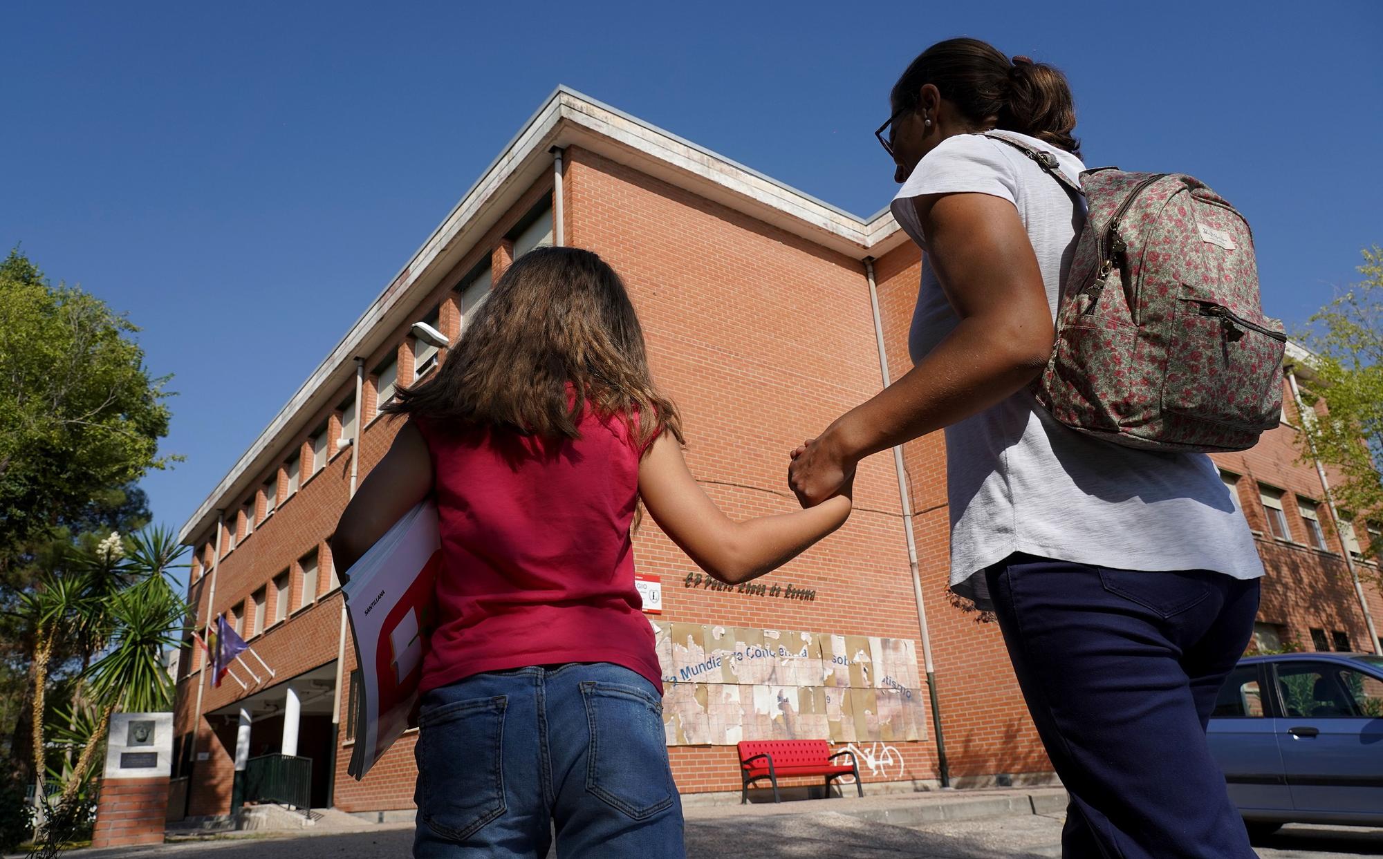 Una mamá acompaña a su hija al colegio