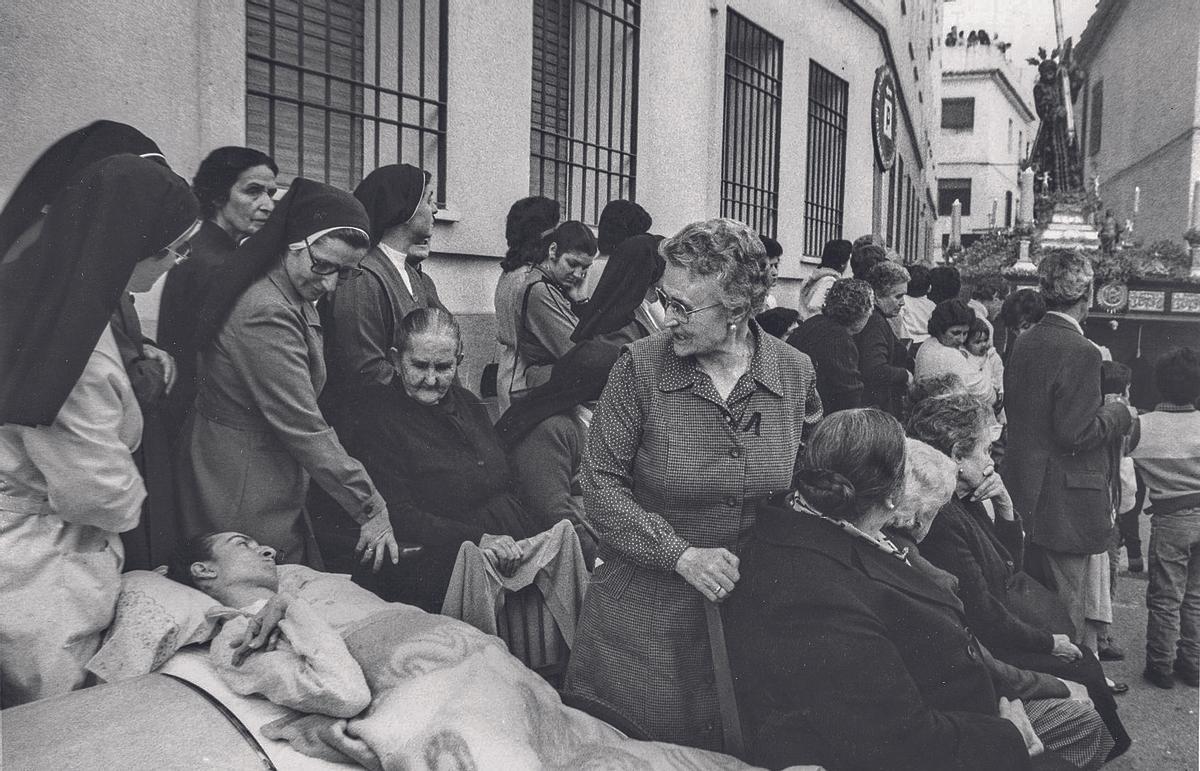 Los mayores de la residencia de Jesús Nazareno esperan el paso del Cristo.