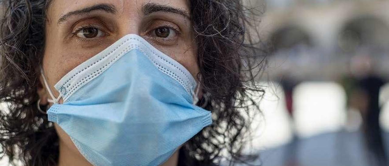 Una mujer camina por el Puente Romano a primera hora de la mañana. // Carlos Peteiro