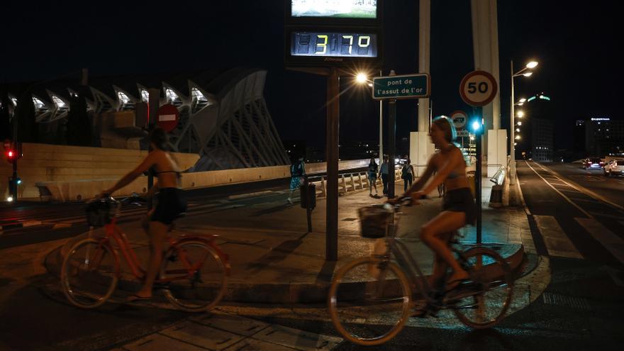 Varias personas montadas en bicis por la noche en València