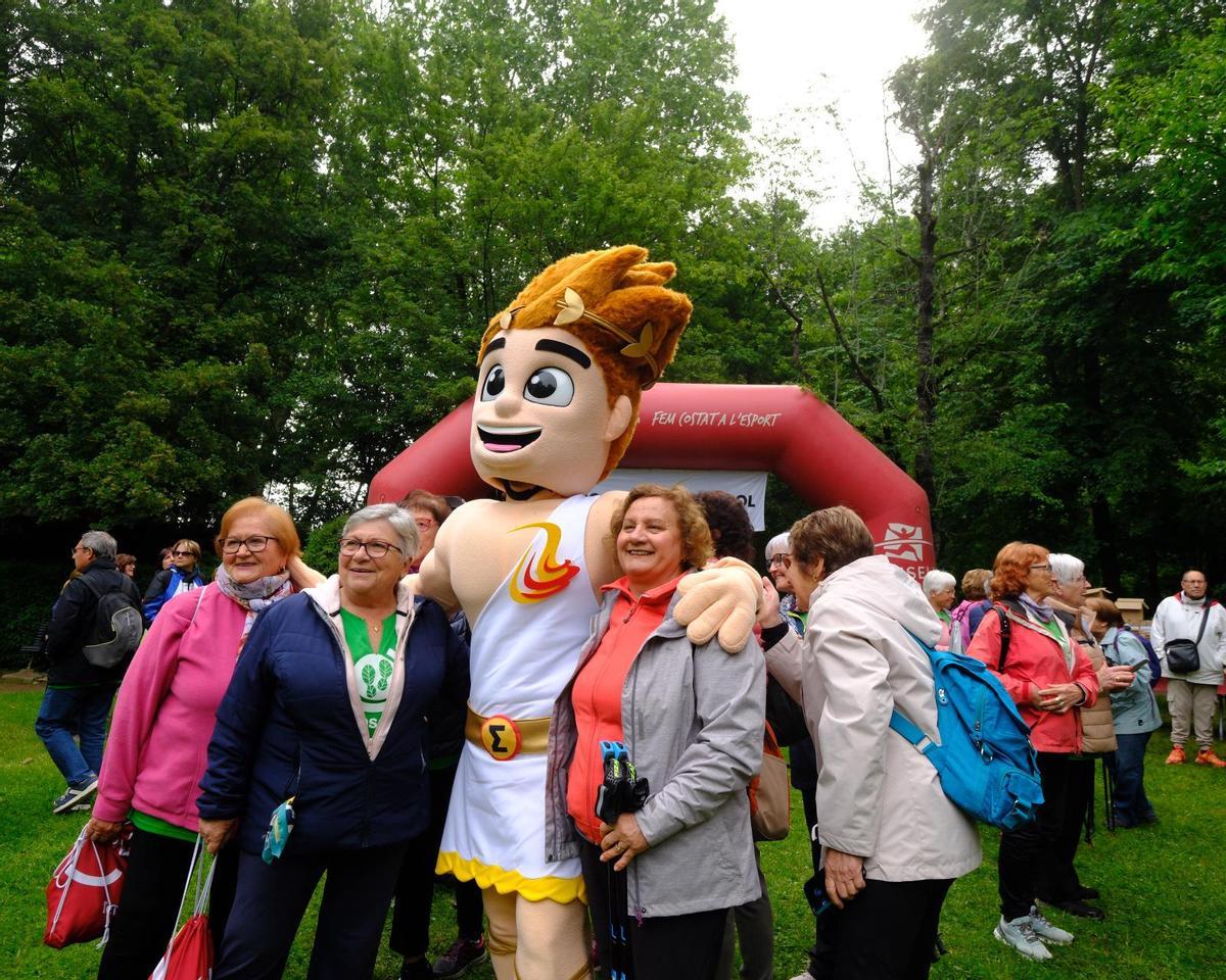 articipants de la trobada esportiva per a gent gran es fotografien amb la mascota dels Jocs Emporion 2026.