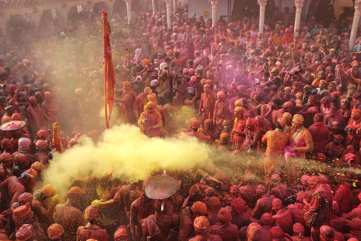 Los devotos hindúes participan en el festival religioso de Holi dentro de un templo en la aldea de Nandgaon, en el estado de Uttar Pradesh, India.