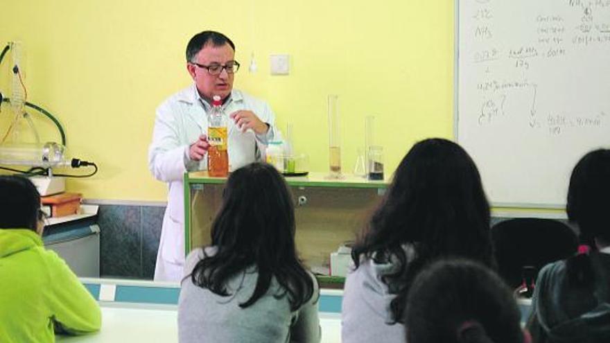 El profesor Santiago Amado prepara uno de sus experimentos para los alumnos en el recreo del instituto llanisco.